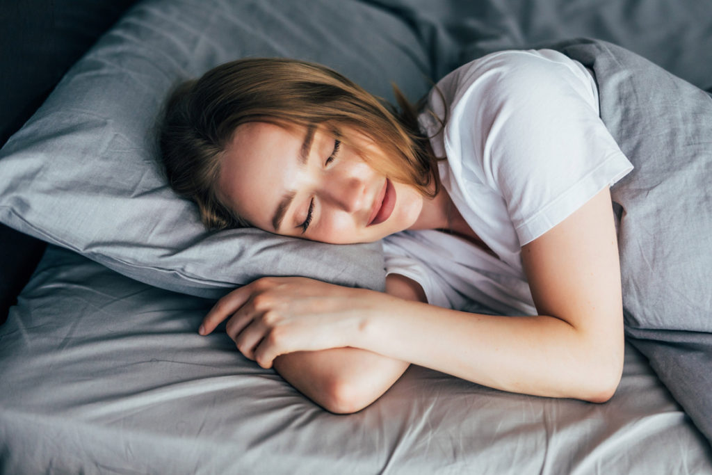 Mulher dormindo feliz mostrando que o sono afeta na aprendizagem