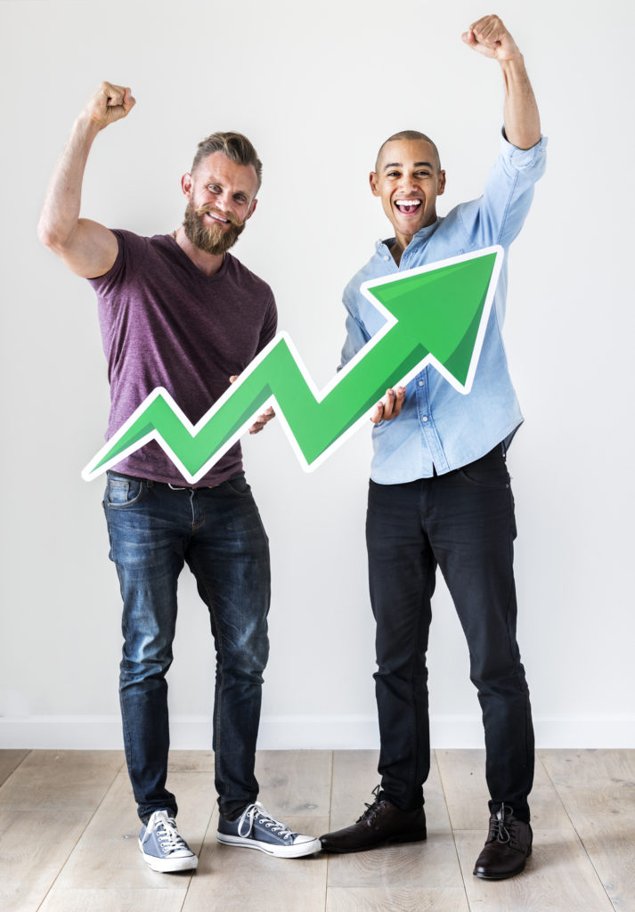 dois casual homem segurando uma seta verde de papelão que aponta para cima, potencial financeiro