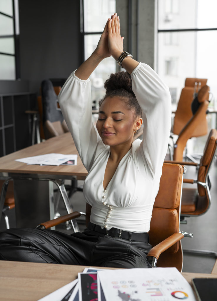 mulher de tiro medio se alongando no trabalho, bem-estar no trabalho