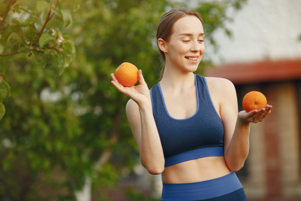 a mulher em um sportwear prende frutas