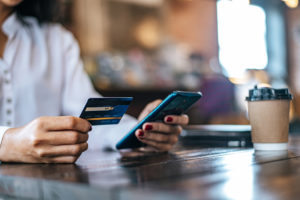 pague as mercadorias com cartao de credito atraves de um smartphone em uma cafeteria