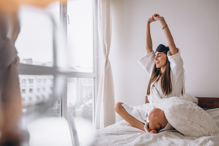 mulher cama desgastar dormir mascara, mulher se alongando na cama após acordar